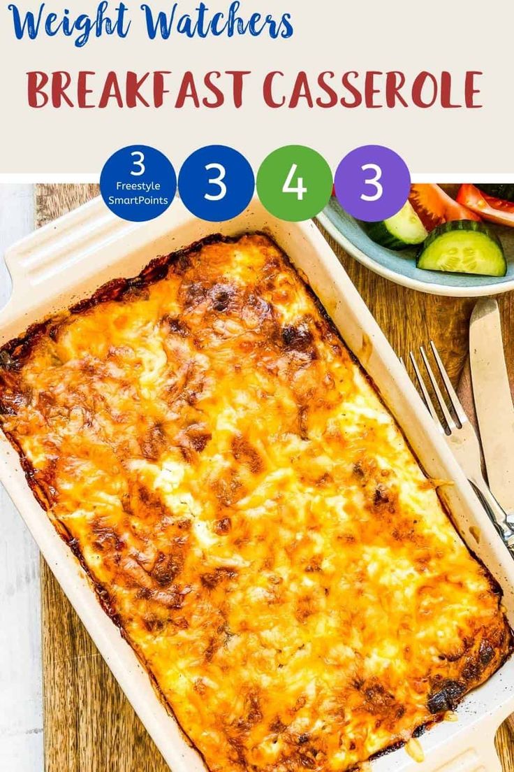 a casserole dish with cheese and vegetables in it on a wooden table next to utensils