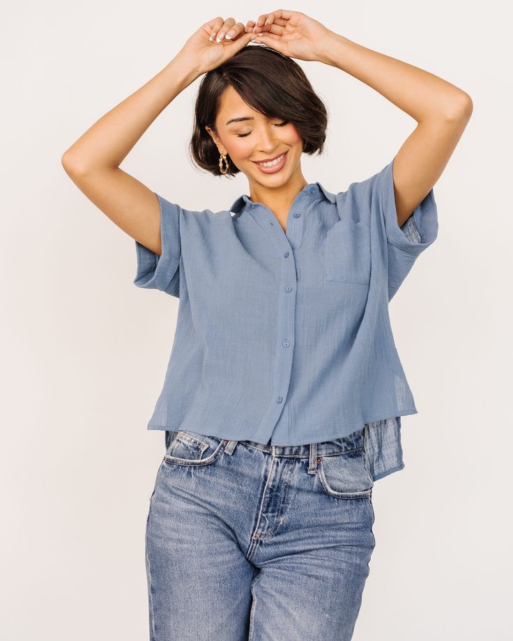 Get our basic Hammond Short Sleeve Top in a solid slate blue color. The textured material and cute button up style are a must have! Blue Blouse With Rolled Sleeves And Relaxed Fit, Blue Shirt With Roll-up Sleeves And Shirttail Hem, Blue Top With Rolled Sleeves For Everyday, Blue Tops With Rolled Sleeves For Everyday, Light Blue Cotton Blouse With Pockets, Everyday Blue Tops With Rolled Sleeves, Light Indigo Button-up Tops For Summer, Blue Shirttail Hem Shirt For Summer, Blue Shirt With Roll-up Sleeves For Everyday