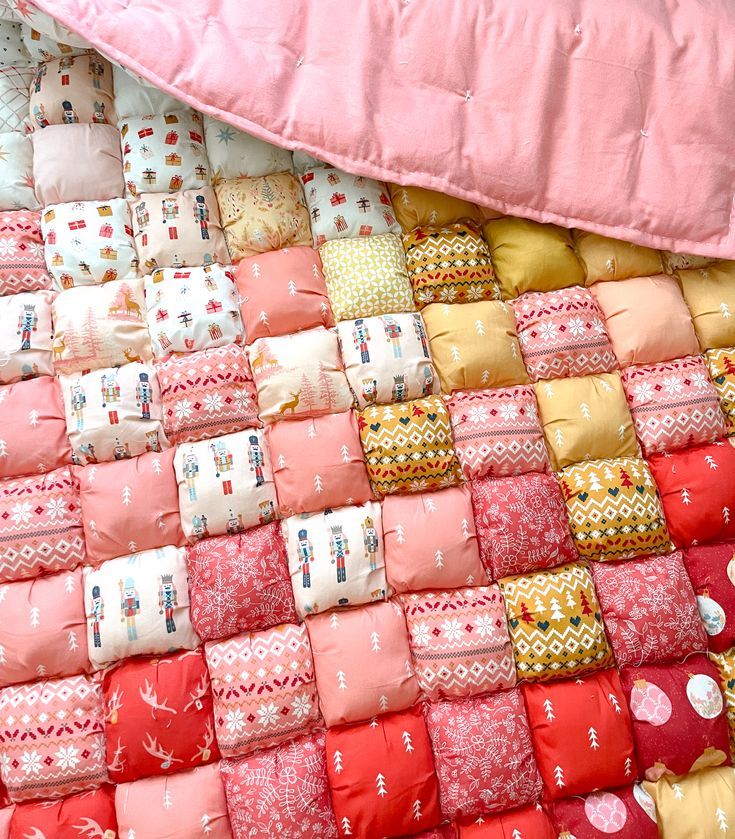 a quilt made out of many different colored pillows and blankets on top of each other