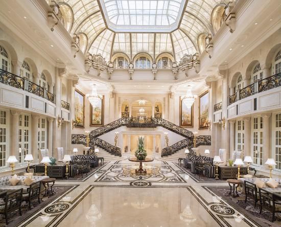 an ornate lobby with high ceilings and chandeliers on the second floor is seen in this image