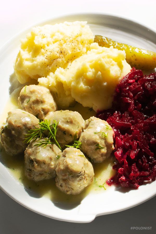 a white plate topped with meatballs, mashed potatoes and cranberry sauce