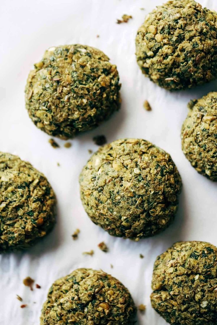 several balls of food sitting on top of a white paper covered in seasoning flakes