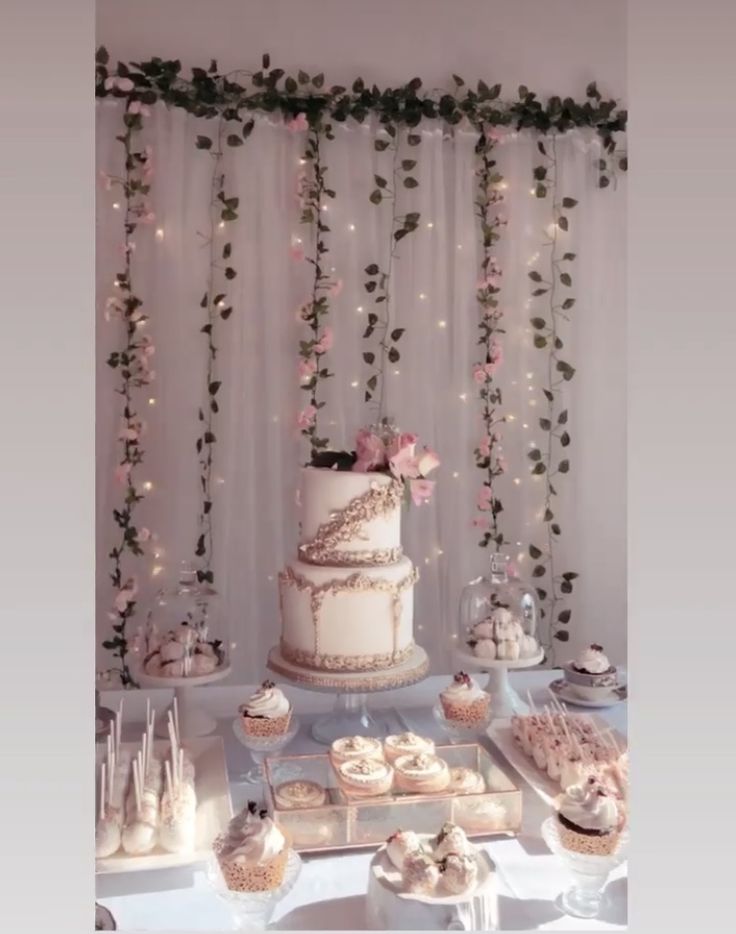 a table topped with a white cake and lots of cupcakes