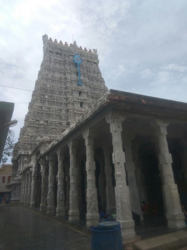 an old building with columns and pillars in front of it, under a cloudy sky