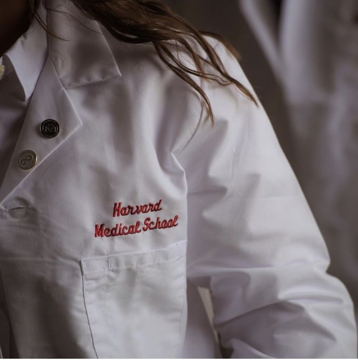 a woman wearing a white lab coat with the words howard medical school written on it