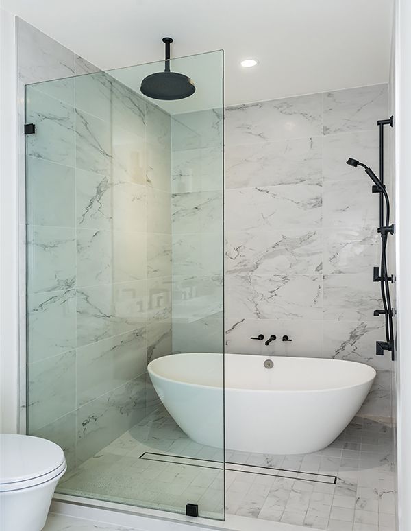 a white bath tub sitting next to a walk in shower