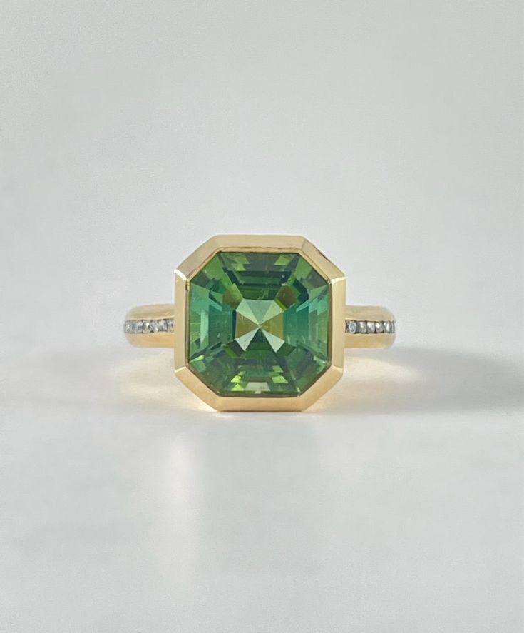 Whopper 13 ct asscher cut Tourmaline in a gorgeous moss green. 2mm chunky 18k yellow gold bezel setting with white diamond accents. Green Tourmaline 18k yellow gold white Diamond Luxury Yellow Gold Tourmaline Emerald Ring, Unique Green Tourmaline Rings, Yellow Gold Tourmaline Emerald-cut Ring, Modern Green Tourmaline Jewelry, Polished Green Tourmaline Jewelry, Phone Items, Asscher Cut, Moss Green, Green Tourmaline