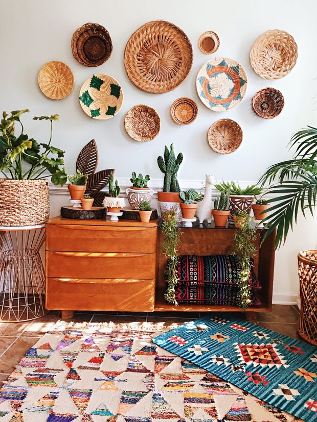 a room filled with lots of plants and baskets on the wall