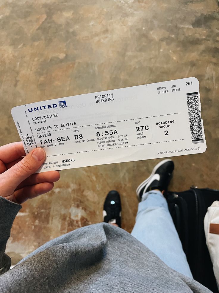 a person holding up a white ticket in front of their feet, with the word united written on it