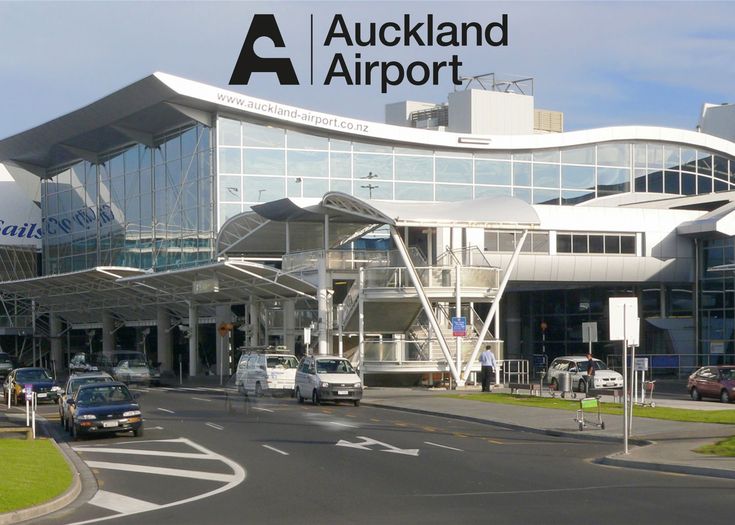 an airport with cars parked in front of it and the words auckland airport