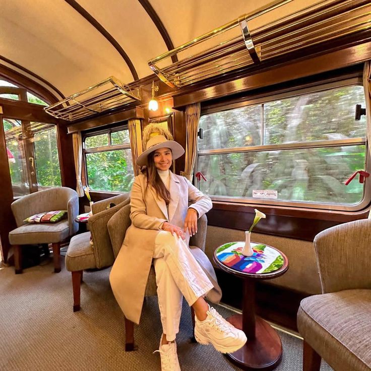 a woman sitting on a bench in a train car