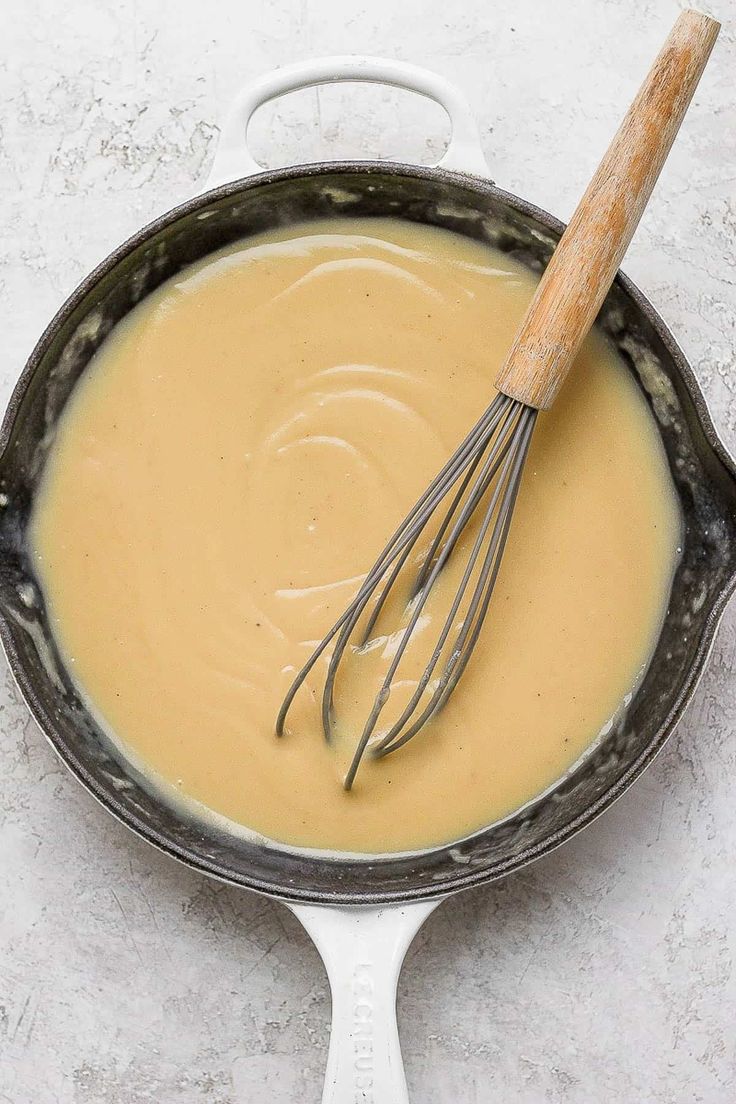 a whisk in a skillet with liquid inside