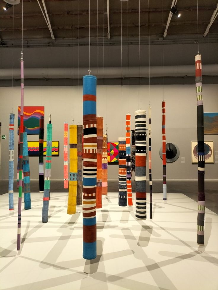 an art gallery with many colorful objects hanging from the ceiling