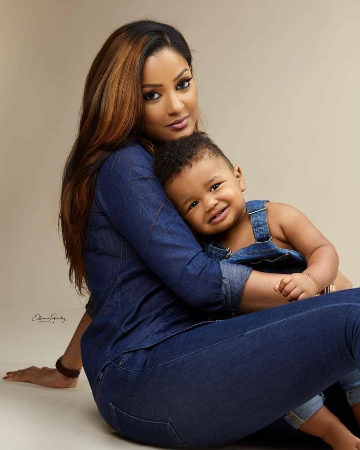 a woman sitting on the ground holding a small child