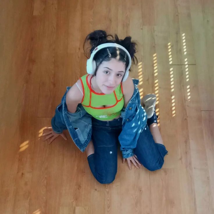 a woman sitting on the floor wearing headphones