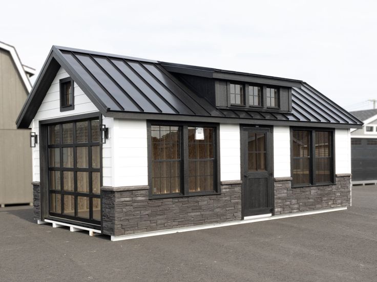 a small house with a metal roof and windows