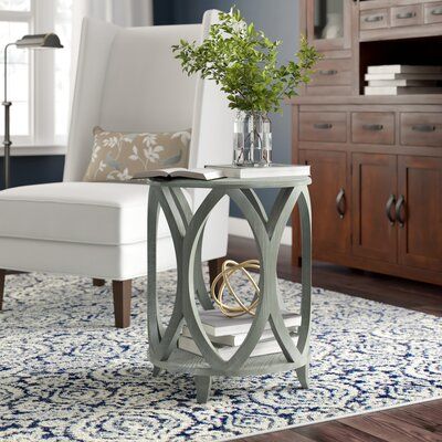 a living room with a white chair and blue rug on the floor in front of it