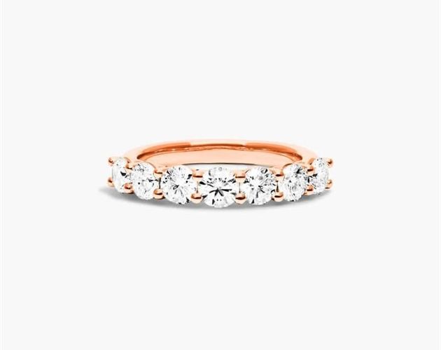 a rose gold ring with three stones on the side and two diamonds in the middle