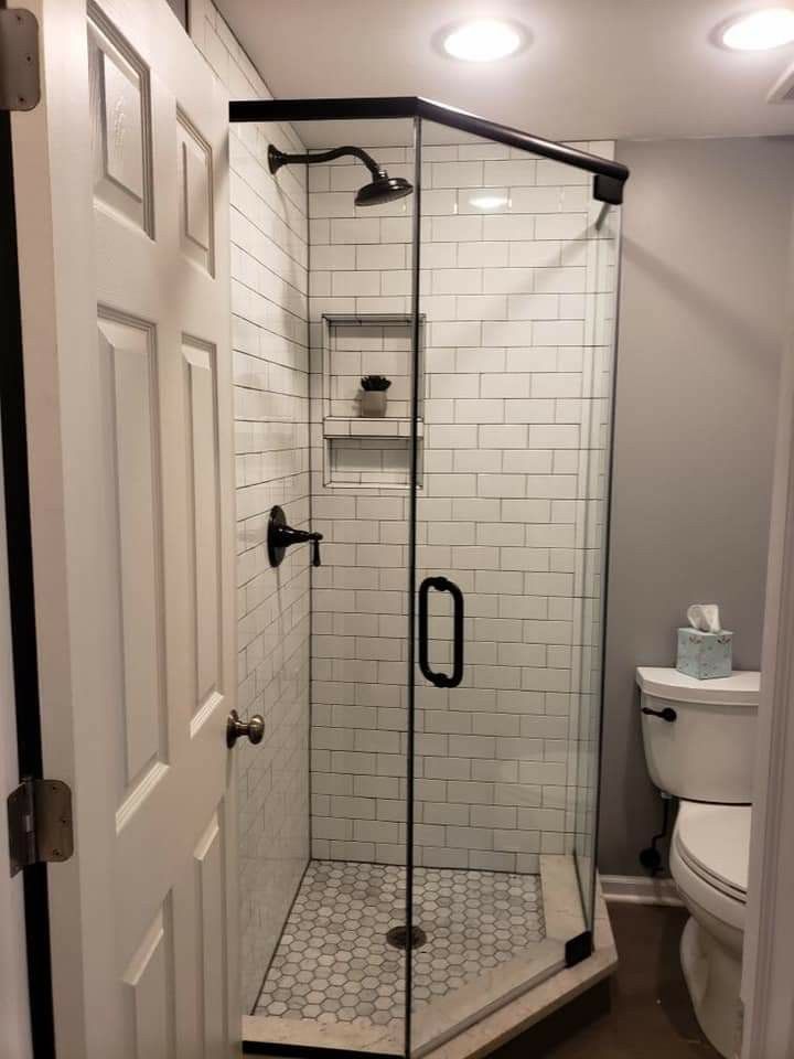 a walk in shower sitting next to a toilet