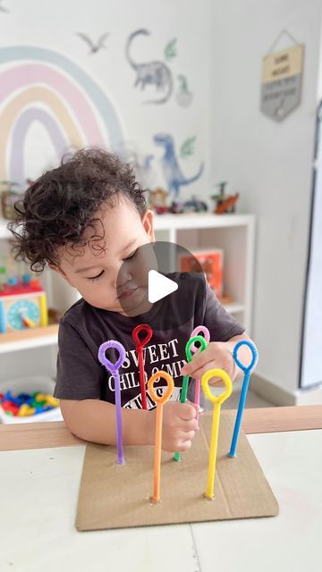 a little boy sitting at a table with some scissors