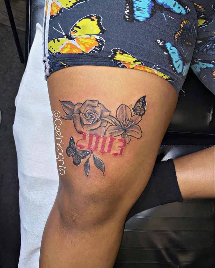 a woman's thigh with butterflies and flowers on her leg, showing the word 2013