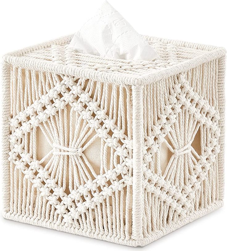 a tissue holder made out of white wicker with an intricate design on the front