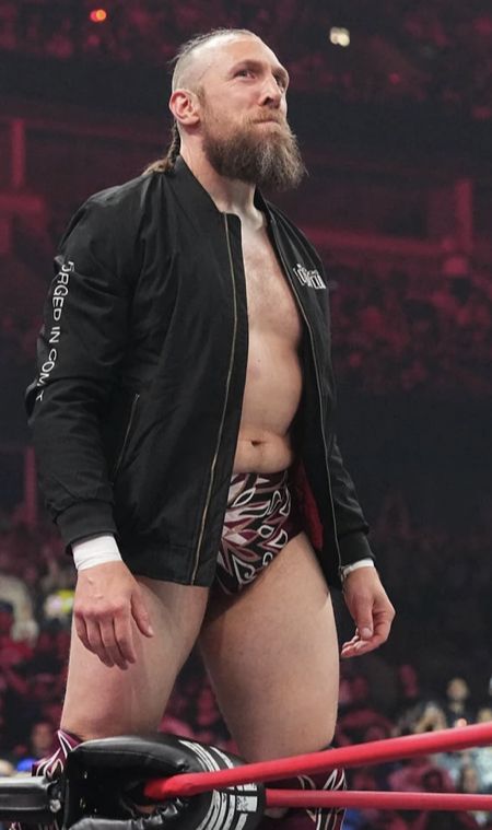 a man standing in the middle of a wrestling ring with his hand on his hip