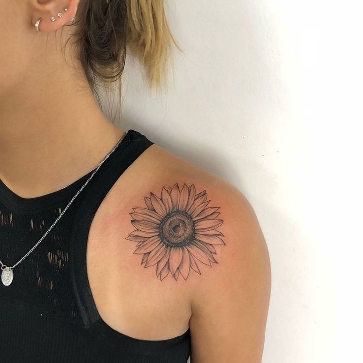 a woman with a sunflower tattoo on her shoulder