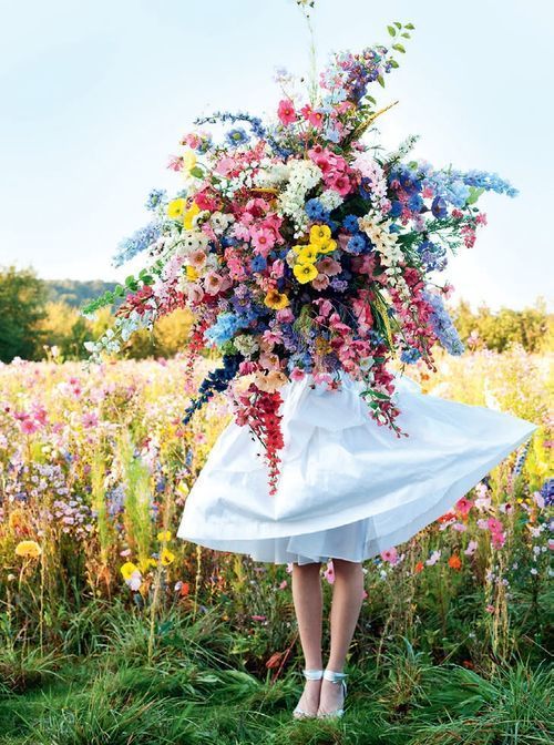 a bunch of flowers that are on top of a white cloth in the grass with blue sky behind them