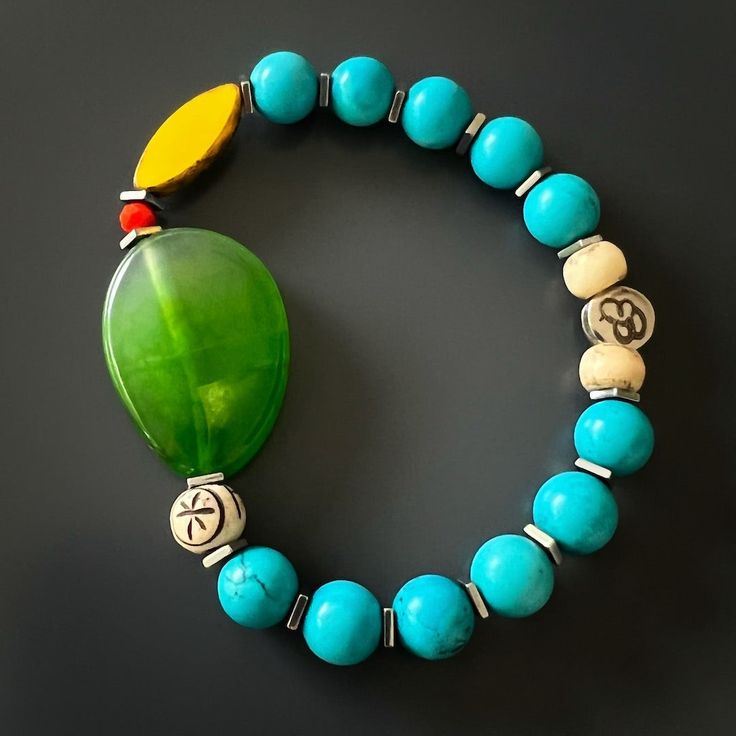 The Green Agate Summer Vibe Bracelet is a stunning accessory that exudes a sense of energy and vitality. The Green Agate stone is said to promote balance and harmony, while the other stones and beads are thought to have their own unique energy properties as well.The bracelet also features a vibrant yellow African bead, which is said to symbolize happiness and prosperity. Together, these elements create a beautiful and vibrant piece that is perfect for adding a touch of color to any summer outfit Handmade Jade Bracelets For Meditation, Agate Bracelets With Polished Beads For Meditation, Holistic Turquoise Beaded Bracelets With Natural Stones, Blue Jade Beaded Bracelet For Healing, Blue Jade Bracelets For Healing, Blue Jade Beaded Bracelets For Healing, Turquoise Agate Beaded Bracelets For Healing, Turquoise Agate Bracelet With Natural Stones, Blue Jade Spiritual Bracelets