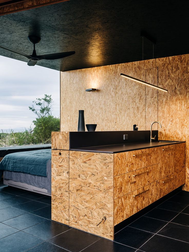 a bedroom with a bed and a sink in it next to a wall mounted ceiling fan