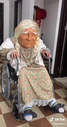 an elderly woman sitting in a wheel chair next to a statue of a person with white hair