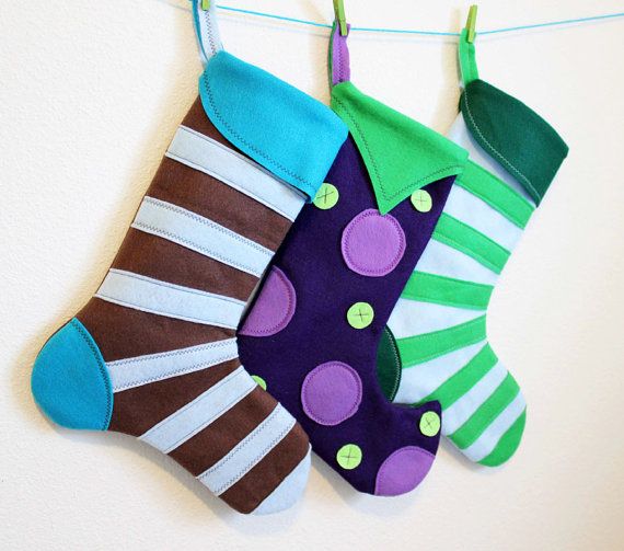 three stockings hanging on a clothes line with green, purple and blue polka dot socks