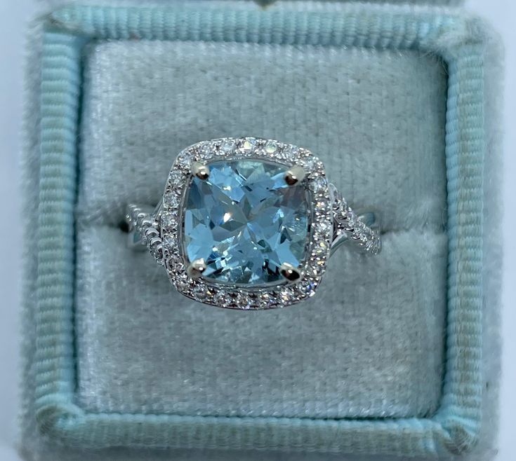 Beautiful aquamarine and diamond ring white gold. The color of this aquamarine is a beautiful color, it's not too pale. The twist design band symbolizes for eternity. Excellent craftsmanship, the diamonds are sparkling. Nice and smooth setting. Also you can stack any band next to this ring and it will sit flush. This ring is nice if you don't want too big of a stone, it's simple and classy ring. The halo measures 12x12mm. Genuine aquamarine cushion cut 8x8mm 1.95 Carats Clarity: VS Eye clean sto Light Blue Diamond Ring With Brilliant Cut, Fine Jewelry Light Blue Diamond Ring With Center Stone, Light Blue Diamond Rings With Prong Setting, Light Blue Diamond Ring With Center Stone, Light Blue Diamond Ring Fine Jewelry, Fine Jewelry Aquamarine Diamond Ring In Light Blue, Light Blue Aquamarine Diamond Ring With Center Stone, Light Blue Aquamarine Ring With Diamond Accents, Light Blue Aquamarine Ring With Brilliant Cut