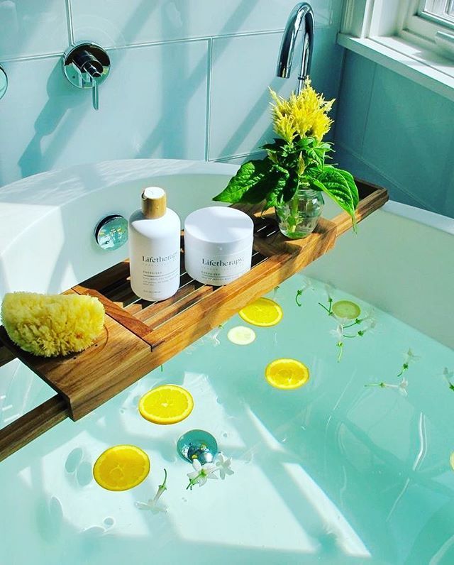 the bathtub is filled with yellow flowers and personal care products