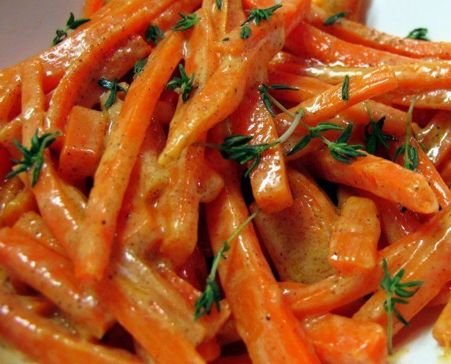 some carrots are piled on top of each other and garnished with parsley