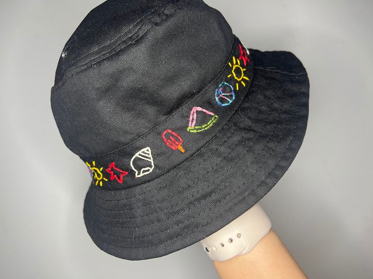 This is the cutest hand embroidered bucket hat for summer! It features little details all around the hat that you'll love. Trendy Summer Bucket Hat With Embroidered Logo, Black Fun Bucket Hat For Summer, Fun Black Bucket Hat For Summer, Fun Black Summer Bucket Hat, Casual Embroidered Adjustable Bucket Hat, Summer Vacation Hats With Embroidered Logo, Trendy Bucket Hat With Embroidered Logo, Handmade Cute Summer Hat, Cute Handmade Summer Hats