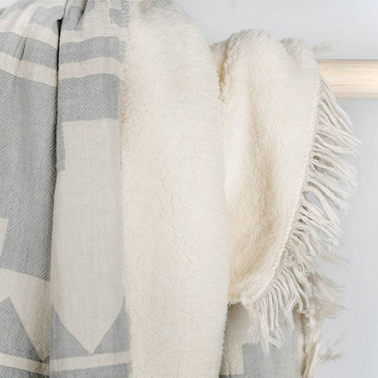 a white and grey blanket hanging on a wall