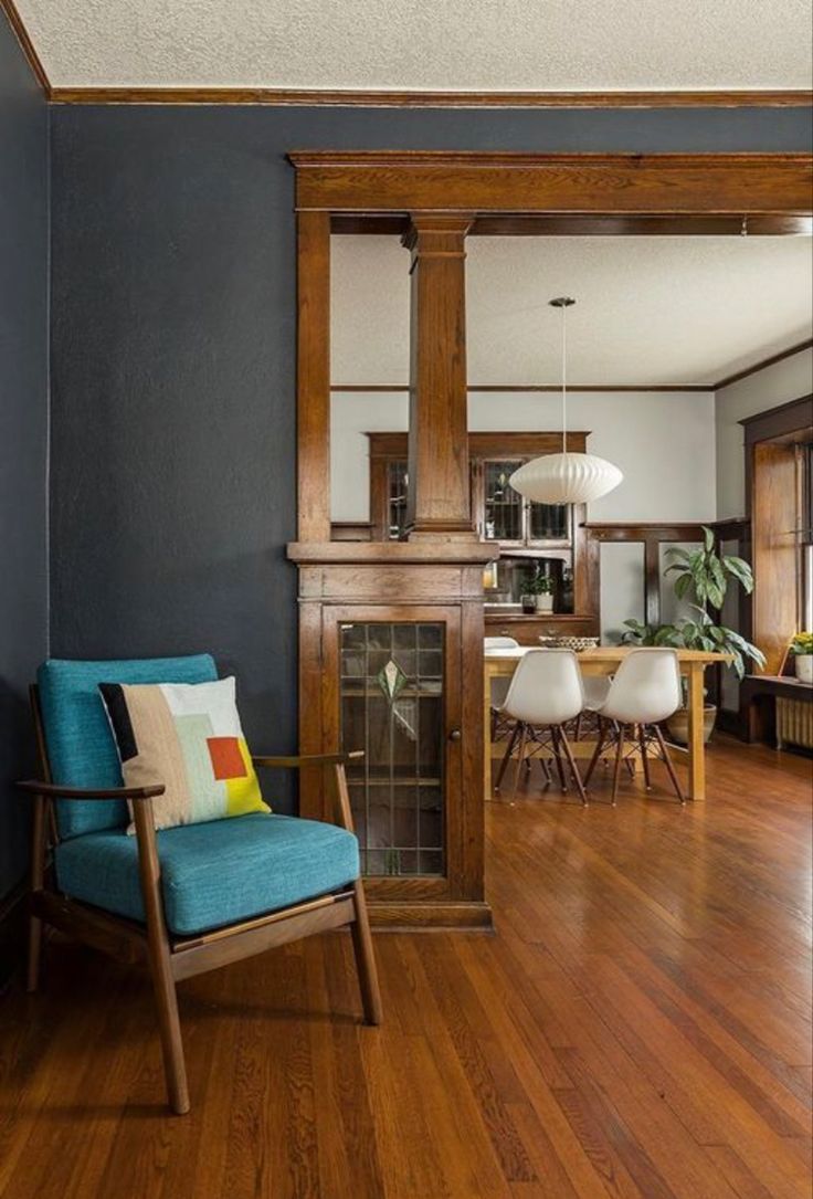 a living room filled with furniture and a fire place in the middle of a wooden floor