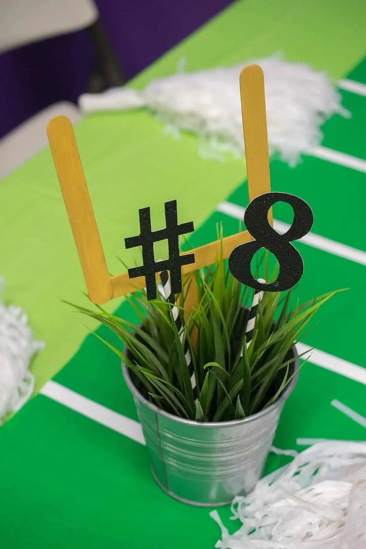 a table topped with a potted plant filled with grass