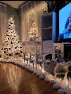 a living room decorated for christmas with white lights and reindeer figurines on the floor