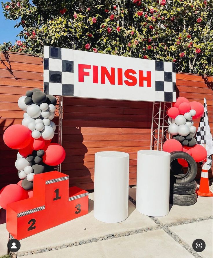 the finish line is decorated with balloons and race track numbers for an event or competition