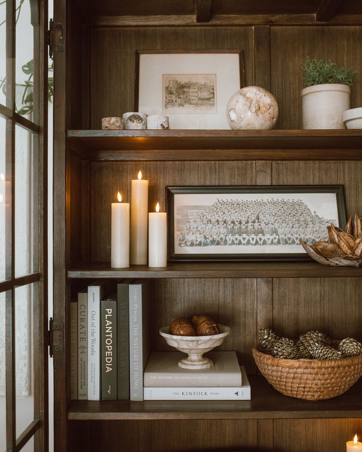 a book shelf filled with books and candles