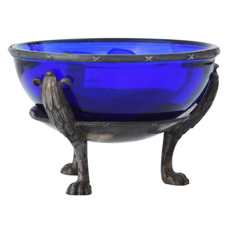 a blue glass bowl sitting on top of a metal stand