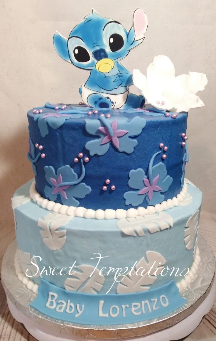 there is a blue and white cake that has lillies on the top, along with words sweet appetizing baby lorenzo