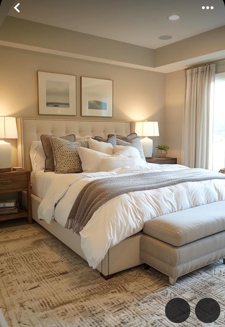 a large bed sitting next to two lamps on either side of a window in a bedroom