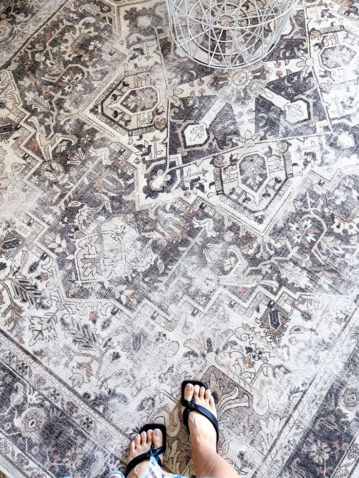 a person standing on top of a rug with their feet in the middle of it