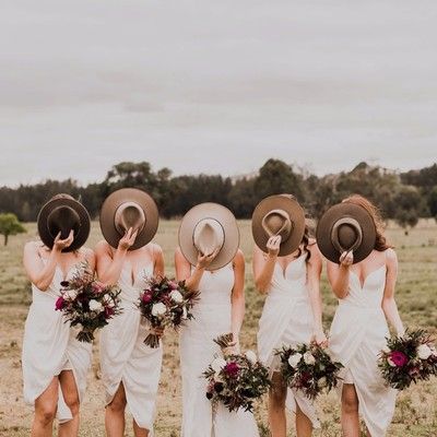 the bridesmaids are all wearing hats and dresses