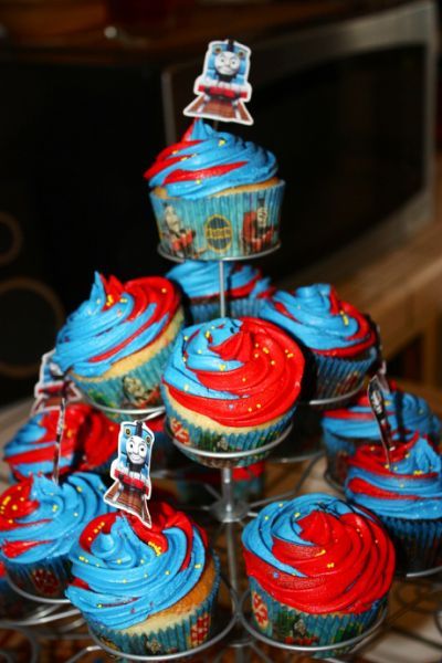 cupcakes with red and blue frosting are arranged on a cake stand in the shape of a tower