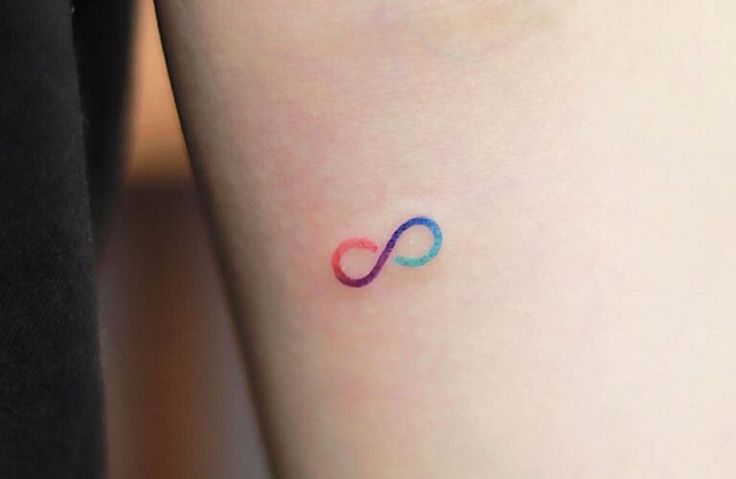 a small tattoo on the leg of a woman's arm with an infinite symbol